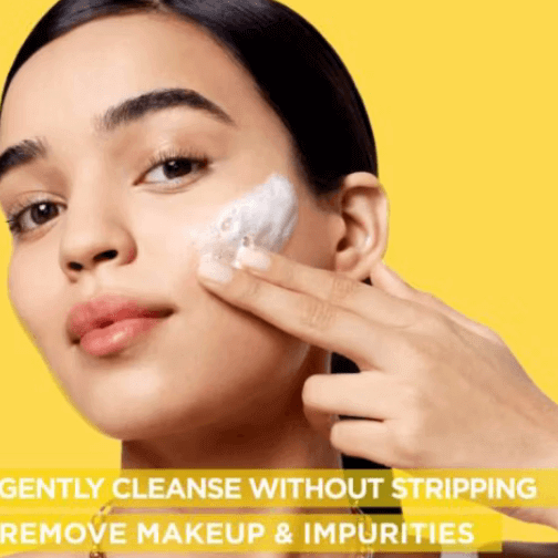 Model applying Garnier Vitamin C Brightening Foam Cleanser for gentle cleansing and makeup removal.