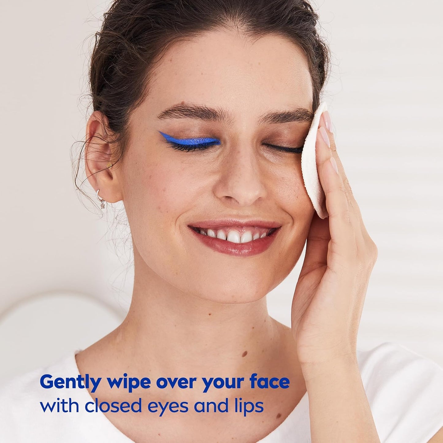 Woman applying a facial product with NIVEA  on a white background