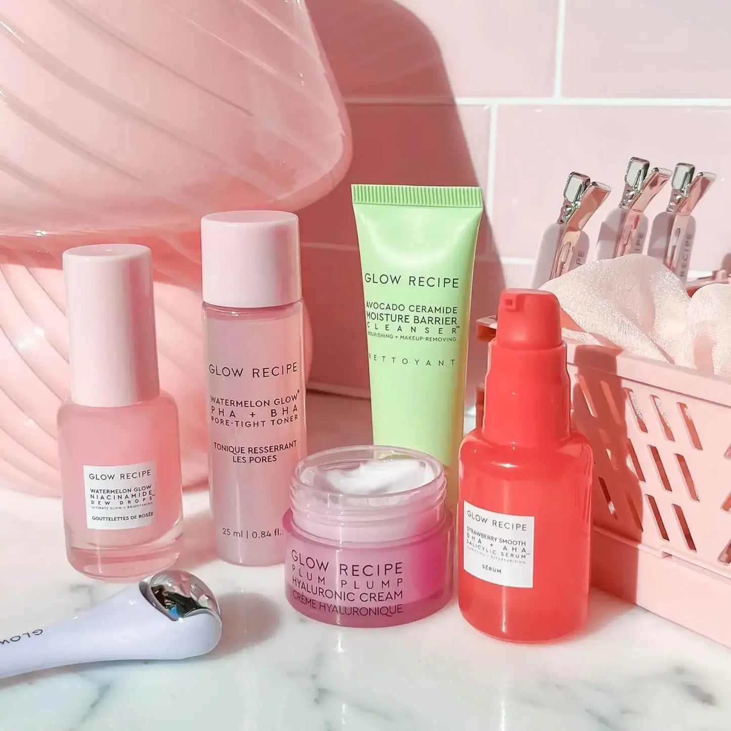 Glow Recipe Fruit Babies Set featuring foaming cleansers, hydrating creams, and skincare serums against a pink backdrop.