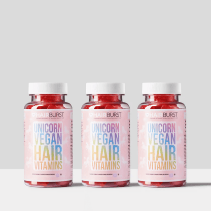 Three bottles of Hairburst Unicorn Vegan Hair Vitamins on a minimalist background, promoting healthy hair growth.
