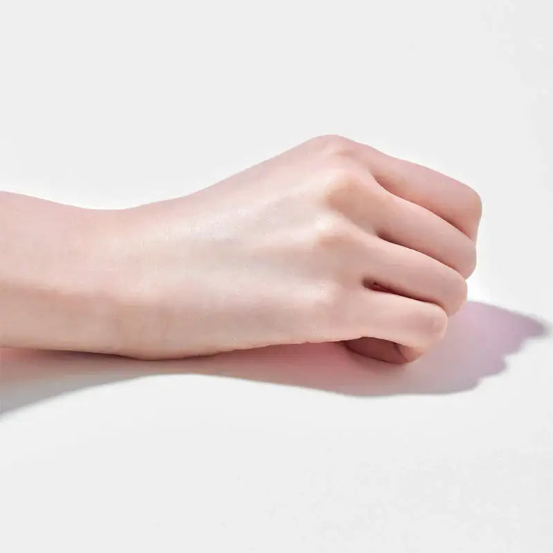Close-up of a smooth, light-skinned hand showcasing the application of a cream or lotion.