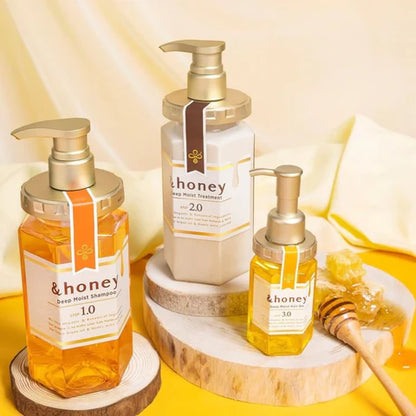 Three bottles of &honey skincare products on a wooden stand with honeycomb and honey on a yellow background.