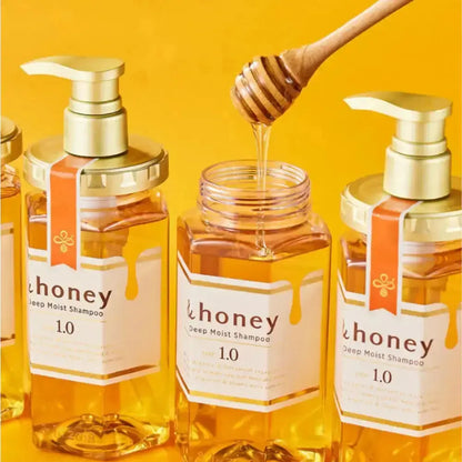 Bottles of '&honey' deep moist shampoo with a honey dipper on a yellow background