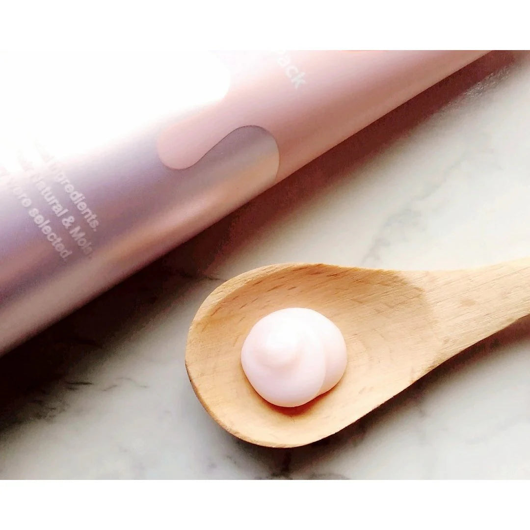 &honey Pink cosmetic product with a droplet on a wooden spoon against a neutral background