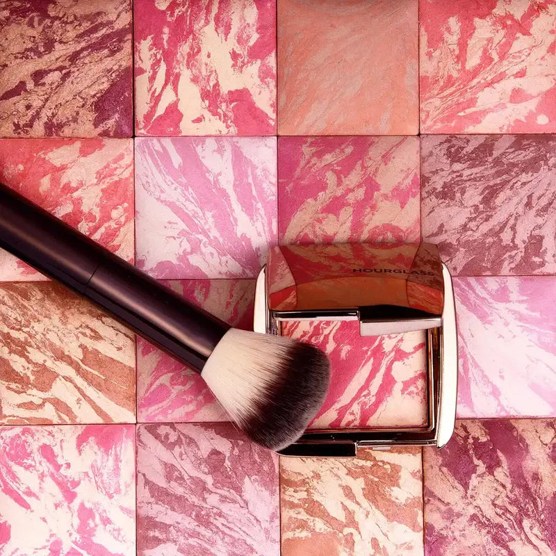 Hourglass Ambient Lighting Blush At Night compact with brush on colorful marbled background.