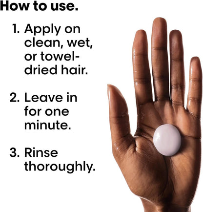 Hand holding a white L'Oreal Professionnel Vitamino Masque text on how to use it, against a white background