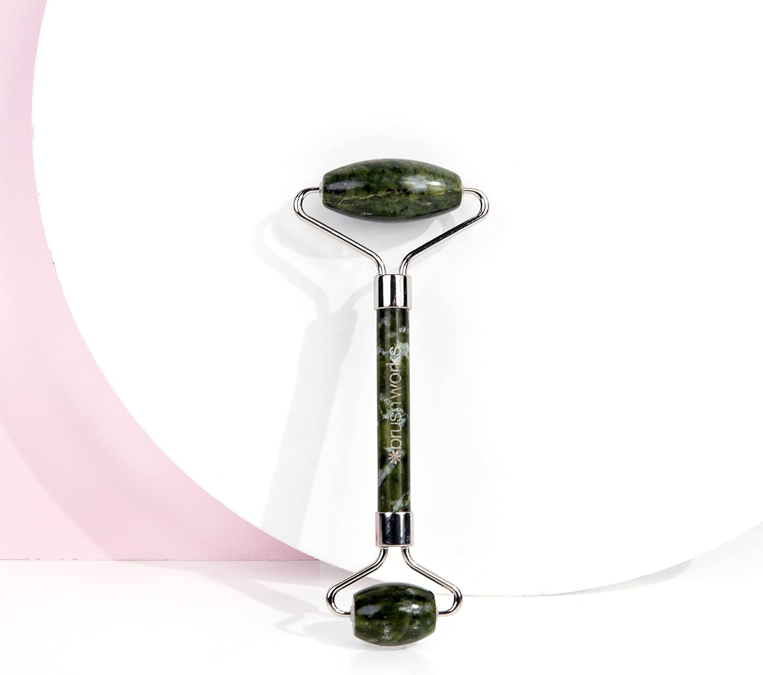 Green jade roller with brand name on a white background