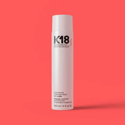 K18 hair product bottle on a red background