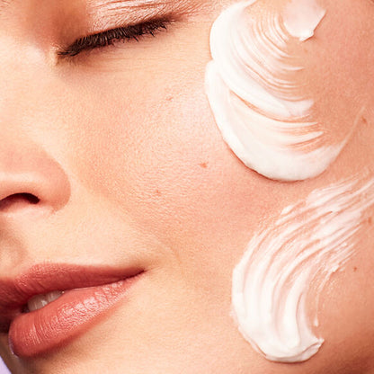 Close-up of a person applying Kate Somerville cream to their face