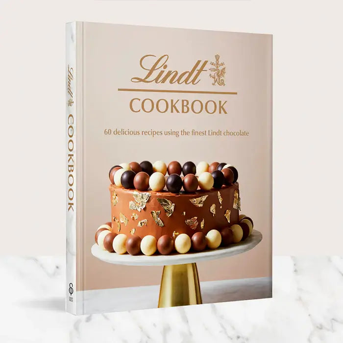 Lindt Cookbook featuring 60 recipes with gourmet chocolate on a marble background.