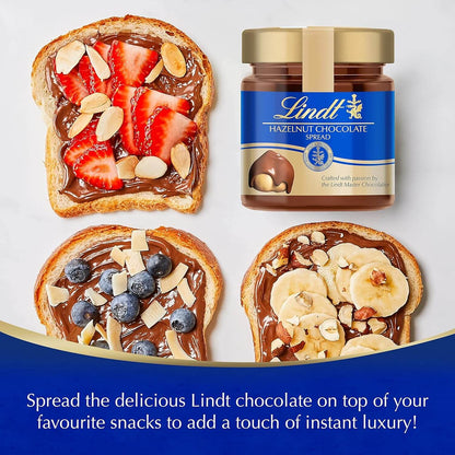 Lindt hazelnut chocolate spread jar with toast topped with strawberries, blueberries, and bananas on a white background.