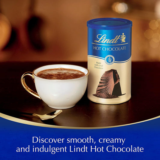 Lindt hot chocolate canister with a cup of hot chocolate on a table.
