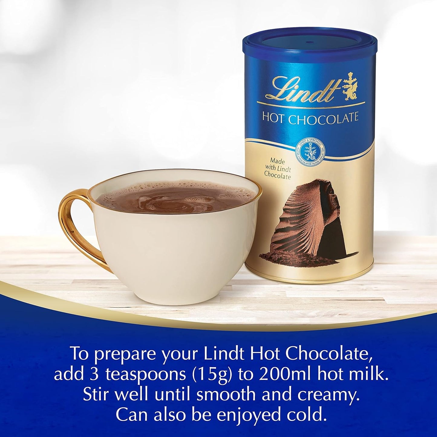 Lindt hot chocolate canister with a cup of hot chocolate on a white background