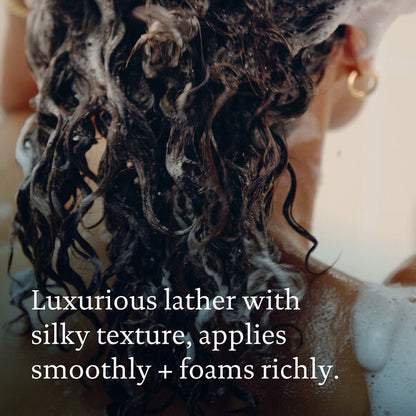 Person with wet, soaped hair and text describing the Living Proof shampoo's texture and application.