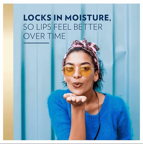 Young woman in sunglasses blowing a kiss; promotes Vaseline's moisture-locking properties for healthier lips.