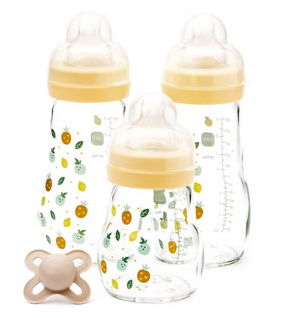 Three MAM baby bottles with yellow caps and fruit pattern, one pacifier on a white background