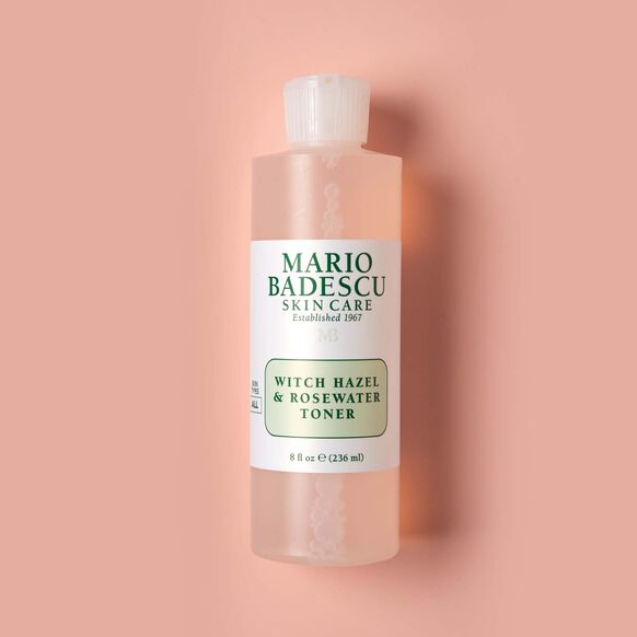 Mario Badescu witch hazel and rosewater toner bottle on a pink background
