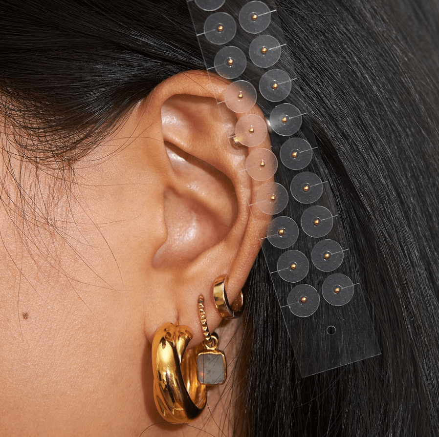 Muihood 24K Gold Plated Ear Seed Kit applied to ear for acupressure and wellness. TheGoodVibes.
