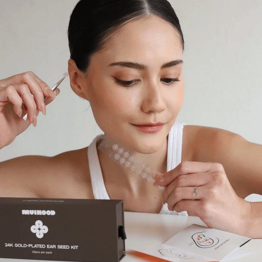 Muihood 24K Gold Plated Ear Seed Kit displayed with a user applying ear seeds, showcasing wellness and luxury.