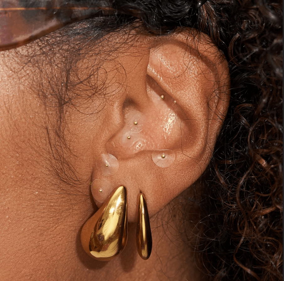 Close-up of ear showcasing Muihood 24K Gold Plated Ear Seed Kit with gold accents for wellness and balance.
