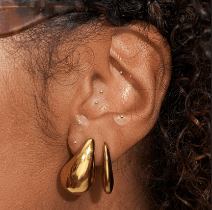 Close-up of ear showcasing Muihood 24K Gold Plated Ear Seed Kit with gold accents for wellness and balance.