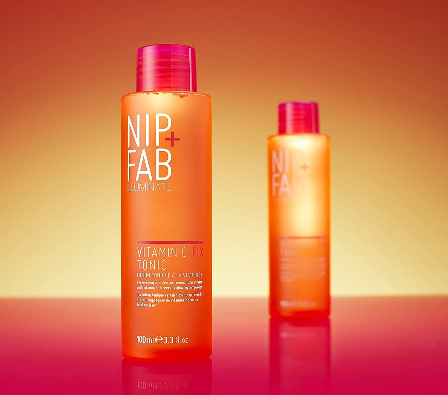 Two bottles of Nip & Fab Vitamin C+ Tonic on a gradient orange background