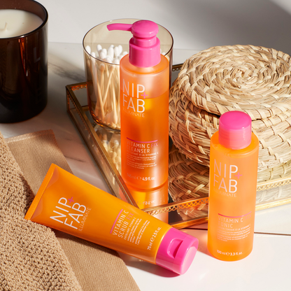 Nip & Fab skincare products on a tray with a candle and wicker basket in the background