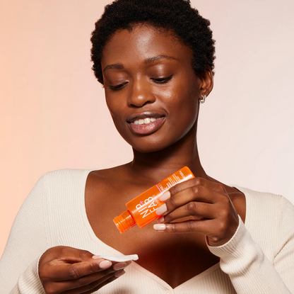 Woman holding Nip & Fab products against a pink background