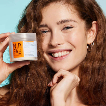 Nip + Fab Glycolic Fix Daily Cleansing Pads held by a smiling woman, showcasing anti-aging skincare.