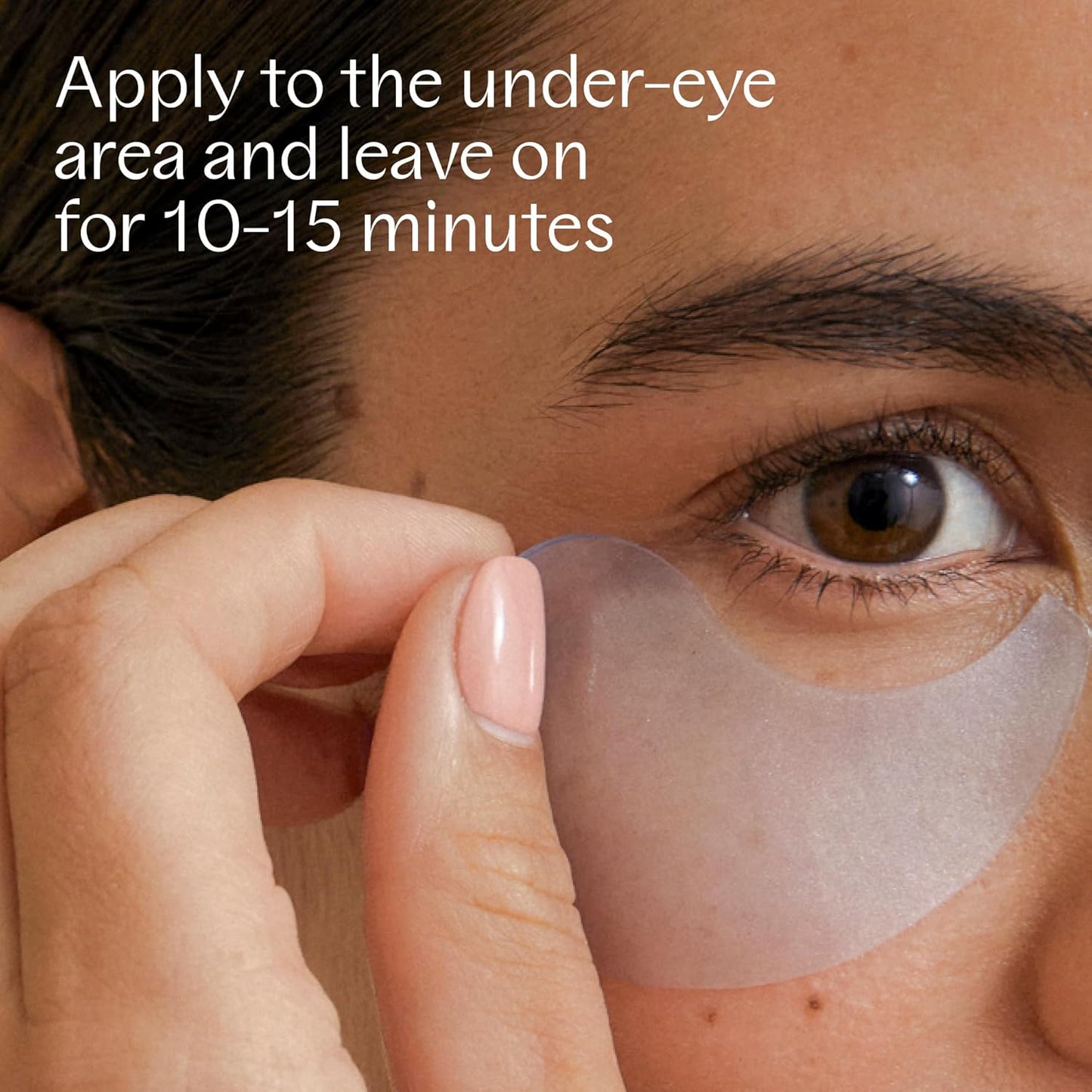 Applying NOBE Arctic Skincare De-Puffing Eye Patches to under-eye area for hydration and puffiness reduction.