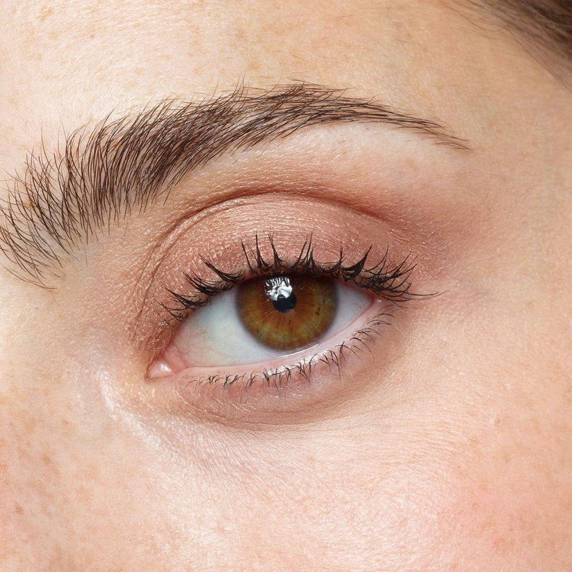 Close-up of a person's eye with NUDESTIX brown iris and eyelashes.