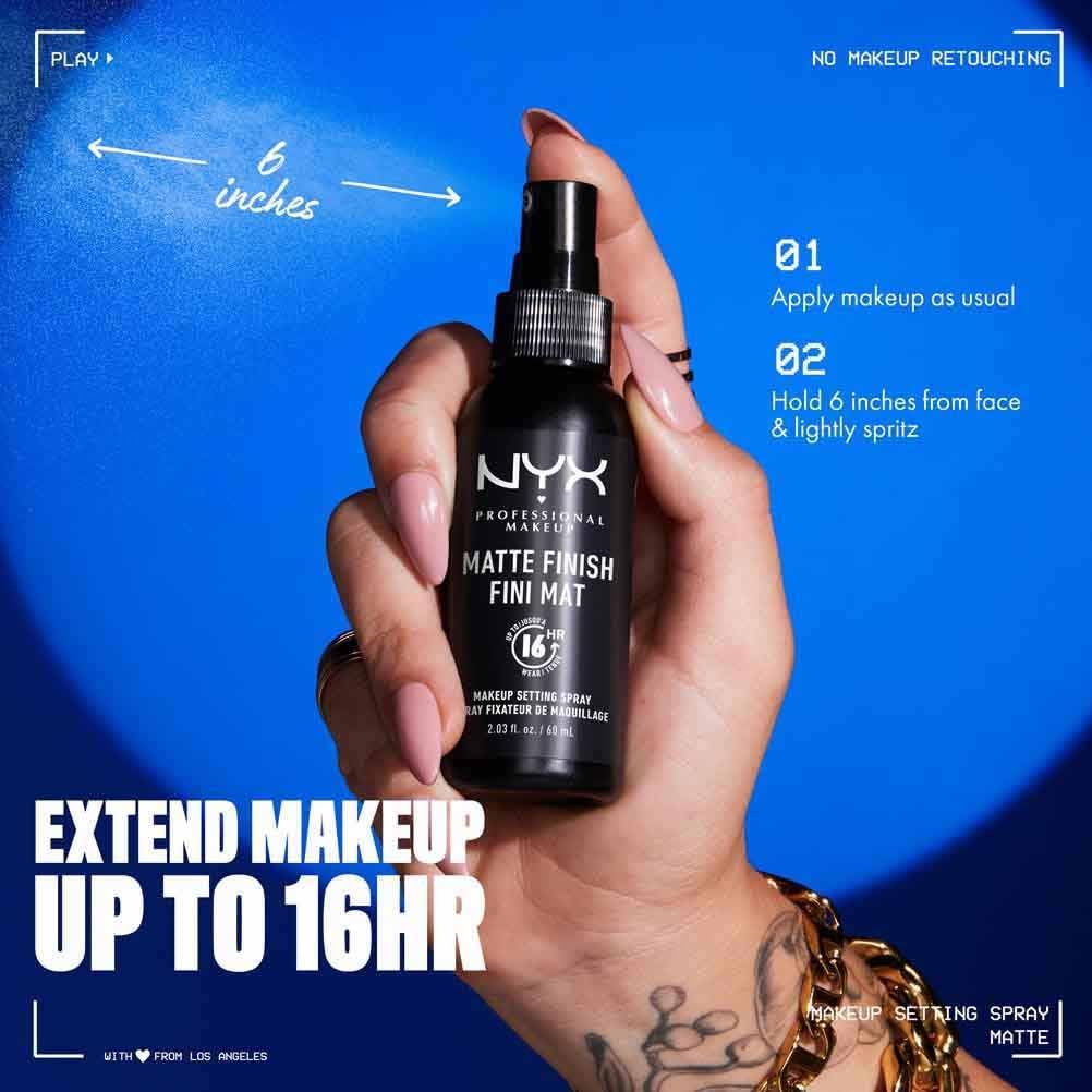 Hand holding a NYX makeup setting spray with text on a blue background