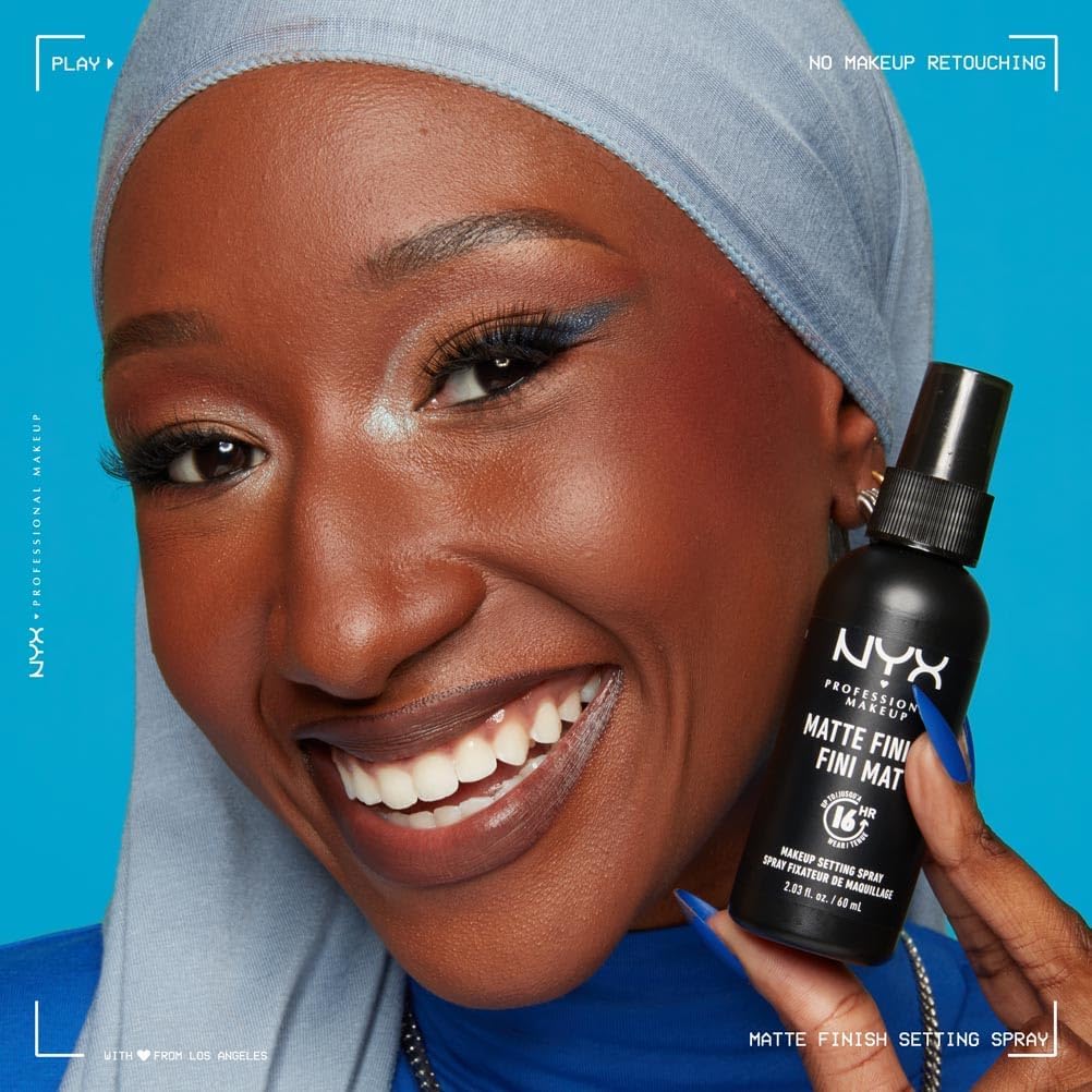 Woman holding a NYX Professional Makeup setting spray against a blue background