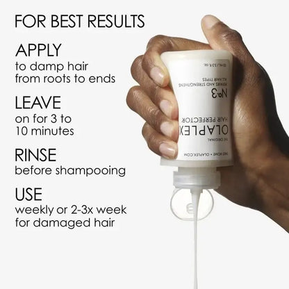 Hand holding a bottle of Olaplex hair product with usage instructions on a white background