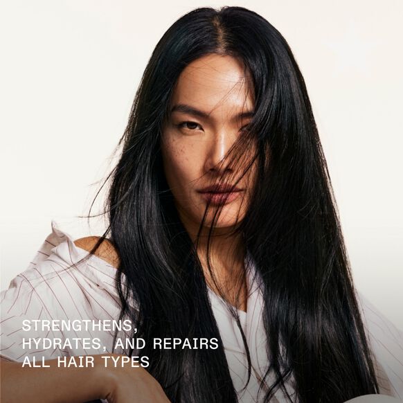 Person with long black hair against a white background, promoting Olaplex hair care product benefits.