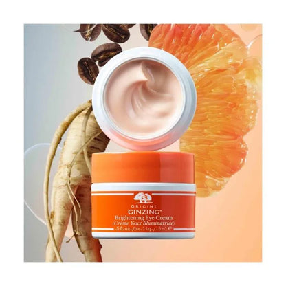 Orange and white jar of Origins Ginzing Brightening Eye Cream with ingredients in the background
