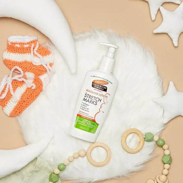 Palmer's Cocoa Butter Formula stretch mark lotion with baby items on a beige background