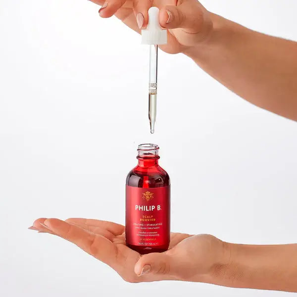 PHILIP B Scalp Booster 60ml dropper being held above a bottle for hair treatment