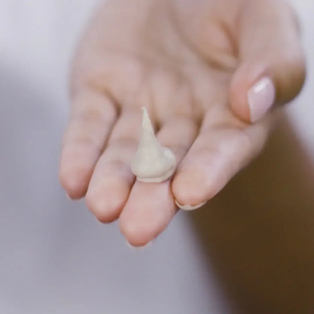 PIXI Glow Mud Cleanser 135ml shown on a hand, highlighting its creamy texture for radiant skin.