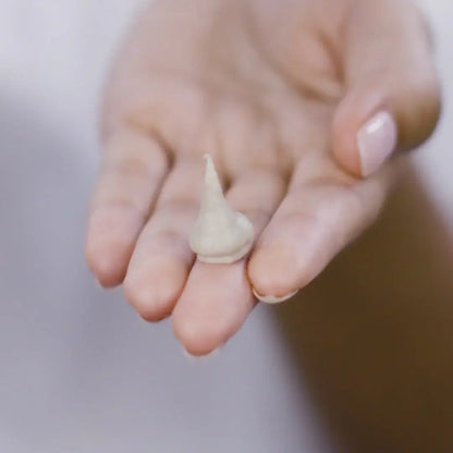 PIXI Glow Mud Cleanser 135ml shown on a hand, highlighting its creamy texture for radiant skin.