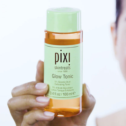  PIXI Glow Tonic bottle held by a person with a white background