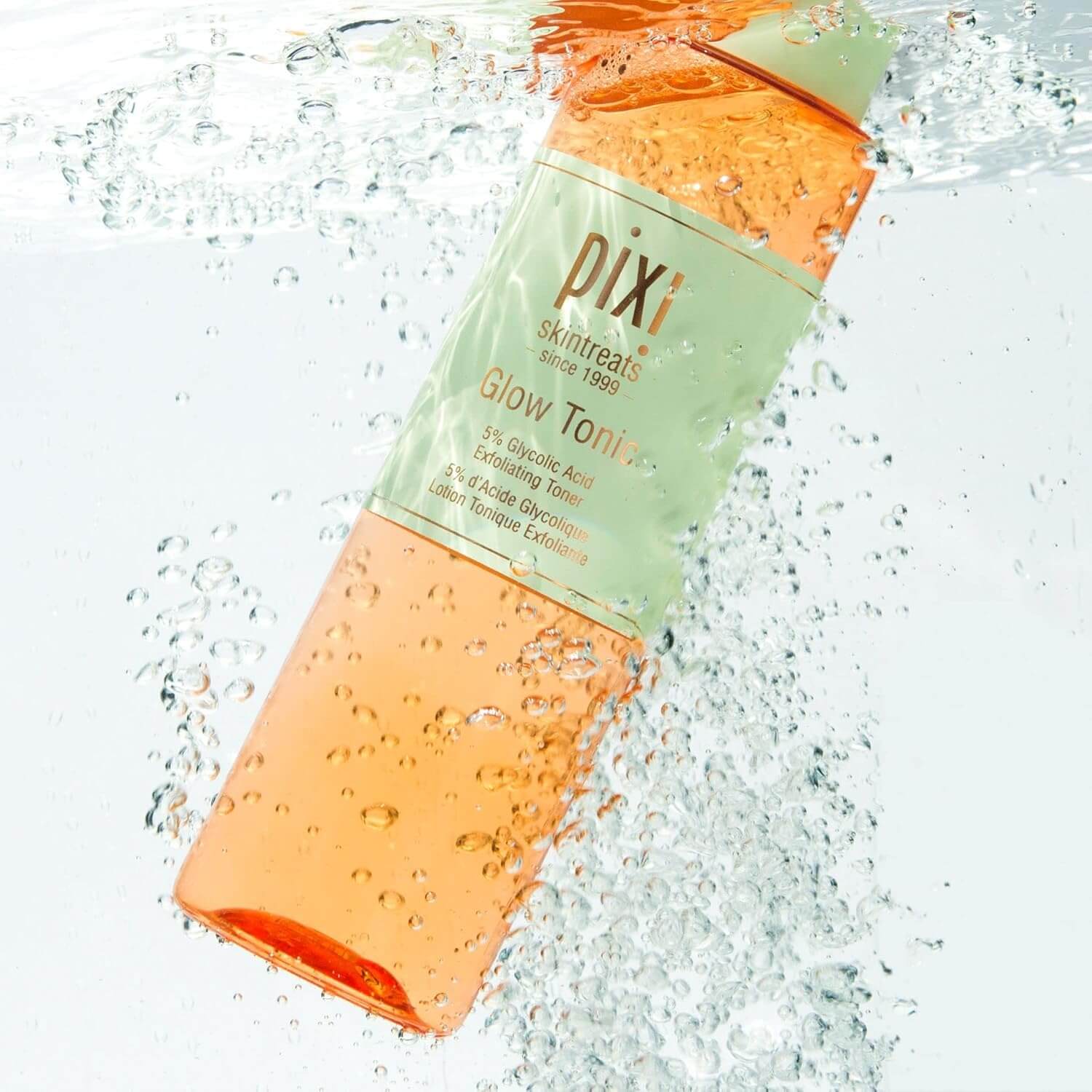Pixi Glow Tonic bottle with water droplets on a light background
