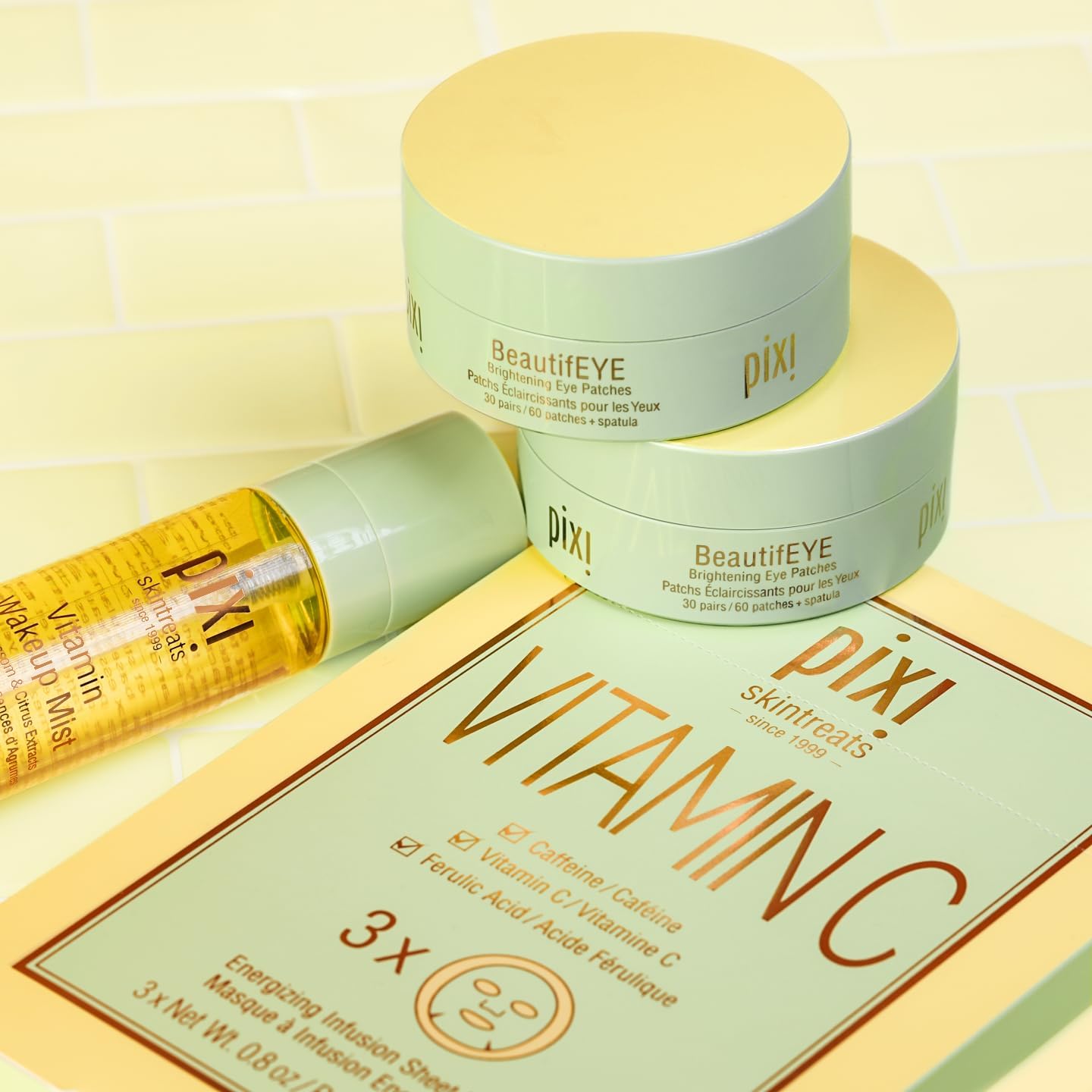  PIXI skincare products including a jar, bottle, and packaging on a yellow background