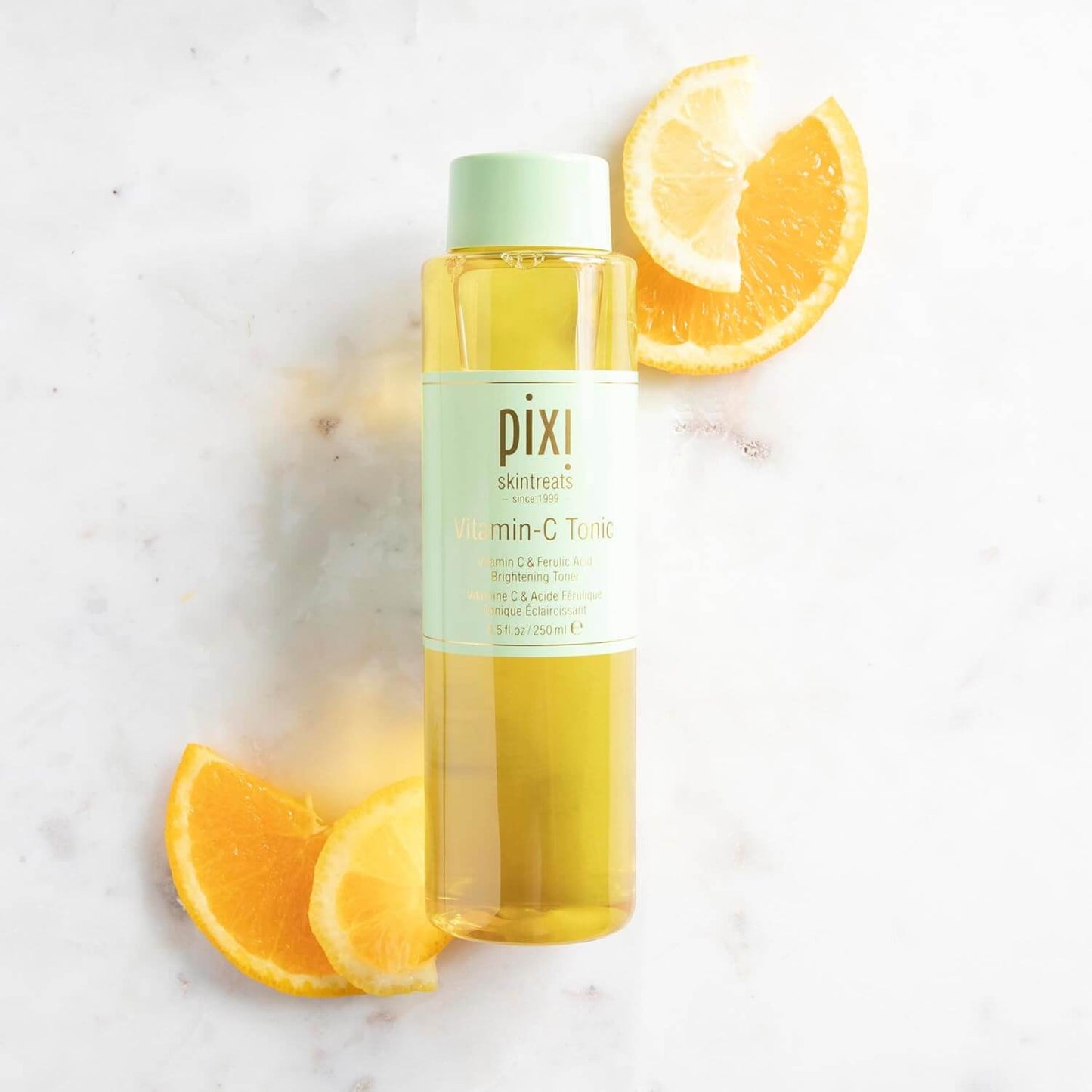 Pixi Vitamin C Tonic bottle with lemon slices on a light background