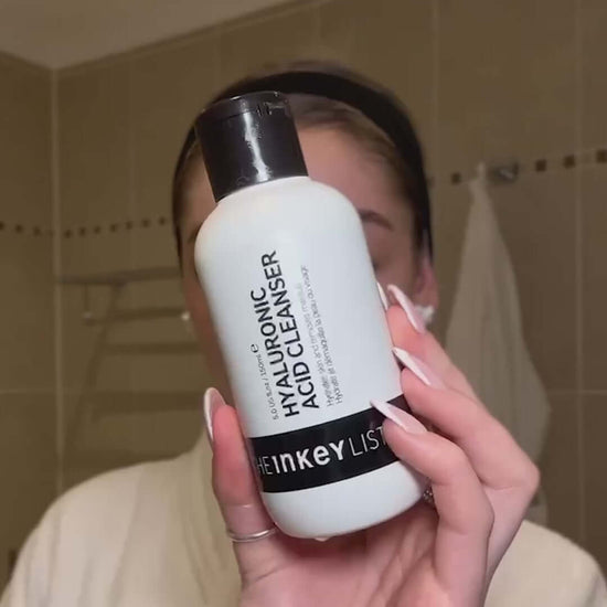 The INKEY List Hyaluronic Acid Cleanser 150ml held by a person in a bathroom, promoting deep skin hydration.