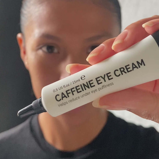 The INKEY List Caffeine Eye Cream 15ml in model's hand, designed to reduce under-eye puffiness.