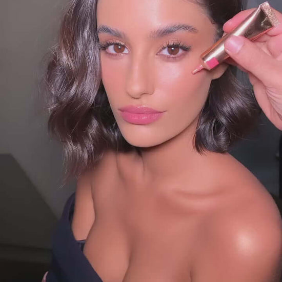 Model applying ICONIC London Sheer Blush - Rose Riot for a radiant, youthful glow on her cheeks.
