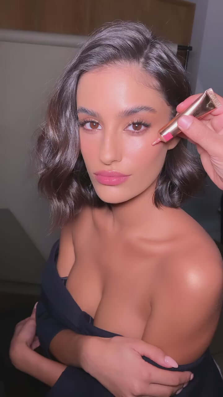 Model applying ICONIC London Sheer Blush - Rose Riot for a radiant, youthful glow on her cheeks.