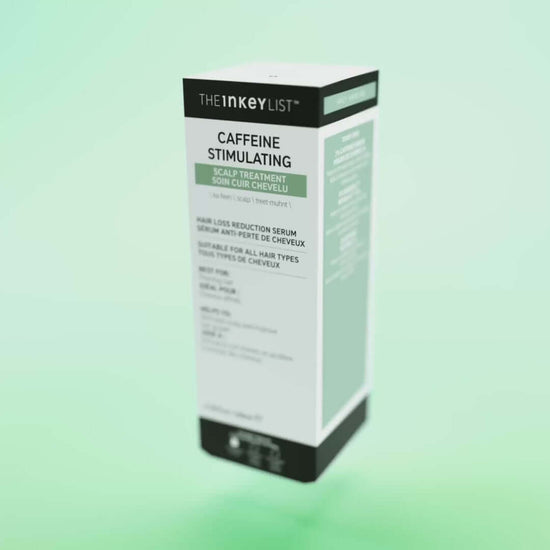 The INKEY List Caffeine Stimulating Scalp Treatment packaging on a green background, promoting hair health.