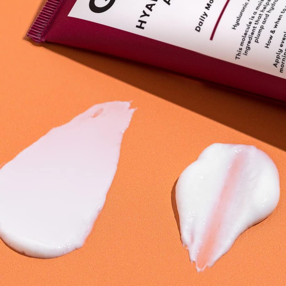 Tube of Q+A product with two swatches of cream on an orange background
